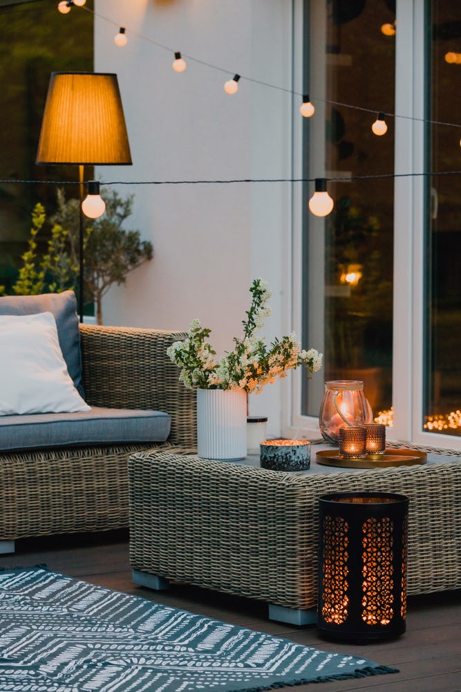 Outdoor patio with lights and plants during the evening.